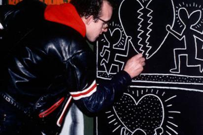 Keith Haring zeichnet ein Graffito an eine Wand. Standbild aus dem Film &quot;The Universe of Keith Haring&quot;.